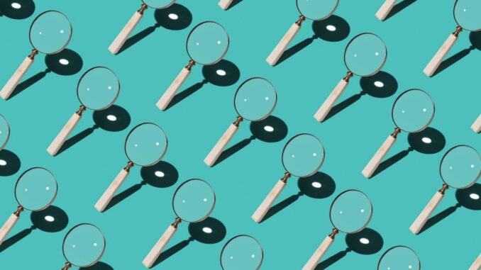 Magnifying Glass Focusing Sunlight Into a Point Repetition on Turquoise Colored Background High Angle View.