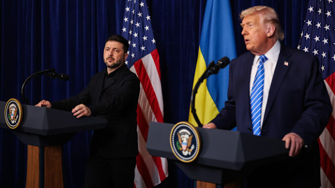 Volodymyr Zelenskyy listens as Donald Trump speaks at podiums with US and Ukrainian flags behind them during a press conference.